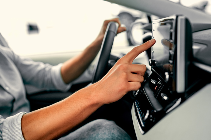 HAnd im Auto tippt auf Bildschirm